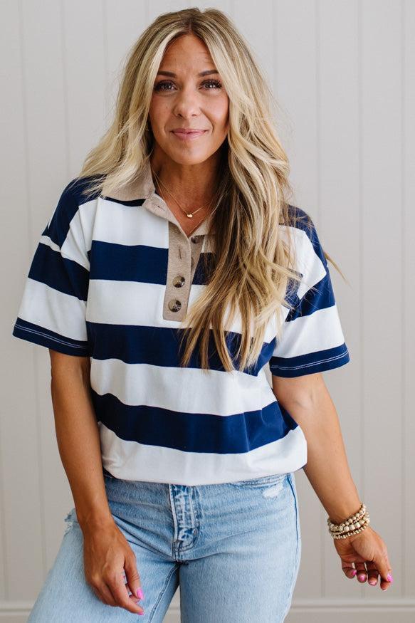 Woman wearing a striped shirt and jeans against a neutral background