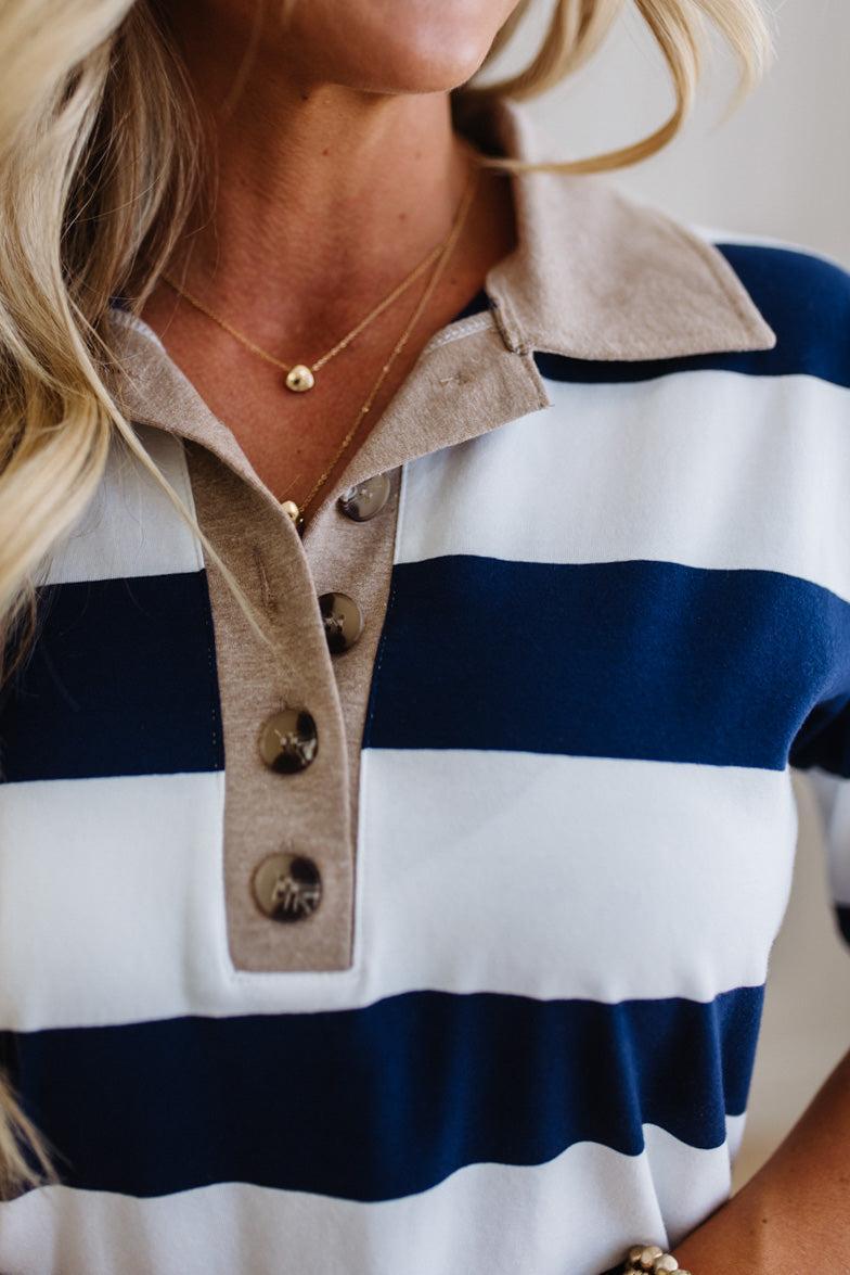 Close-up of a person wearing a striped shirt with a collar and buttons.