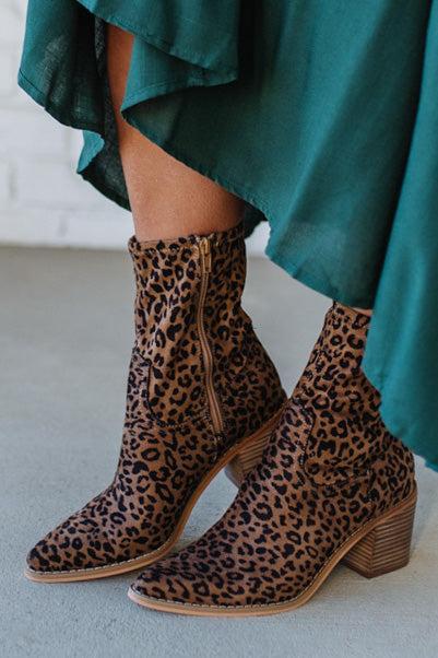 Person Wearing Leopard print, side zipper Sleek Ankle Hugging Booties with a green skirt.