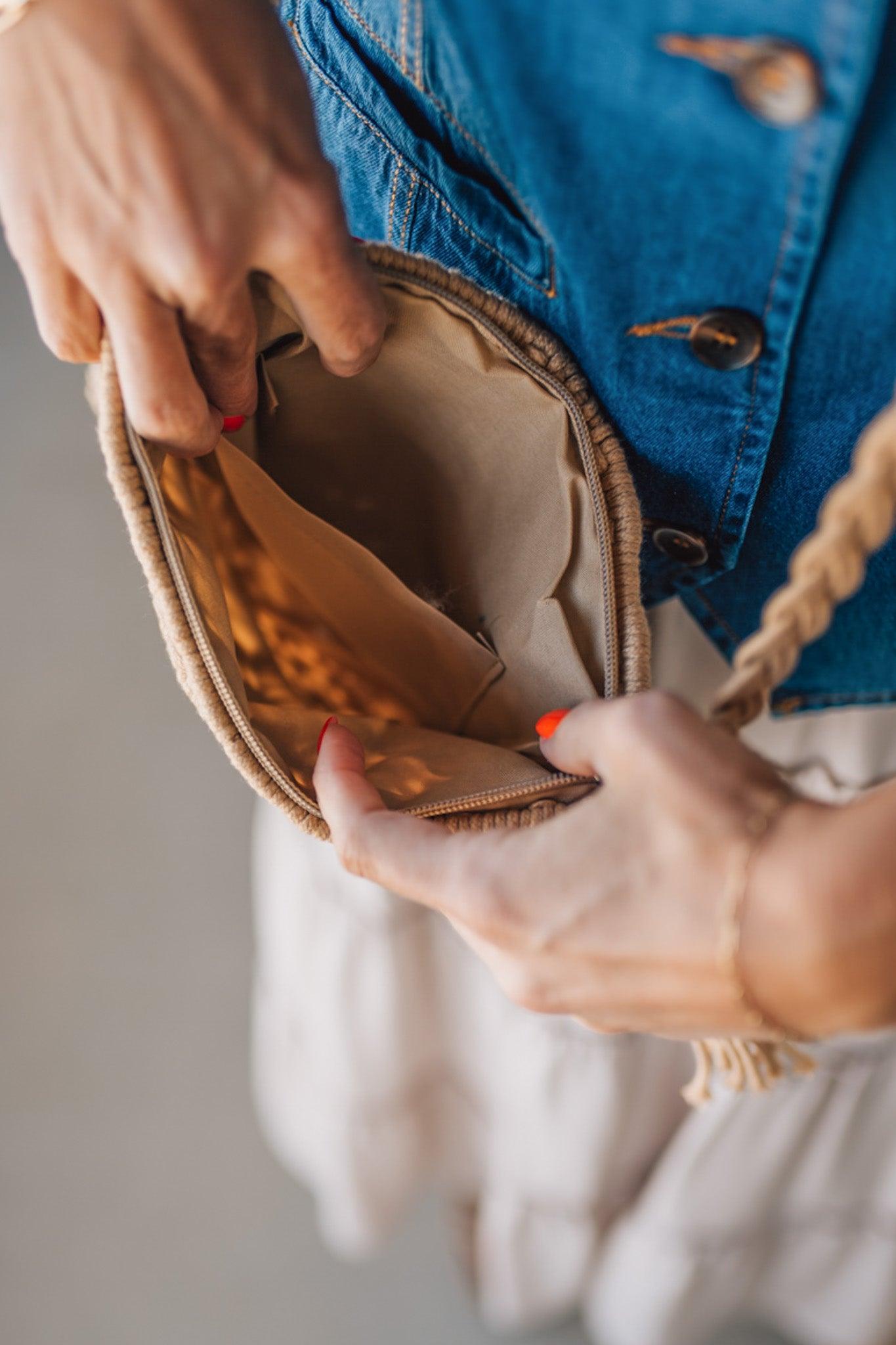 Blonde woman wearing a Macrame Woven Design sling bag with Tassel Zipper Pull.
