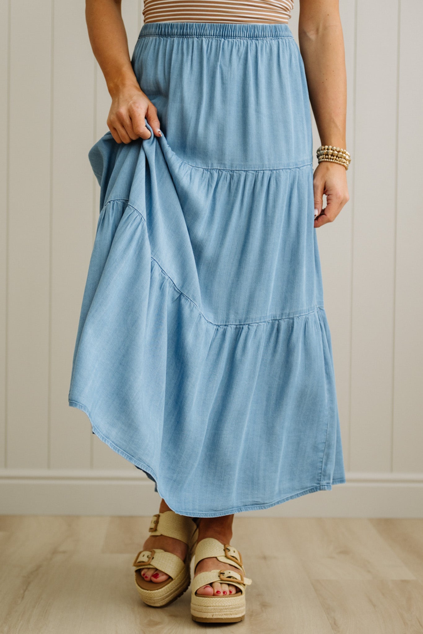 Person wearing a blue skirt with a neutral background