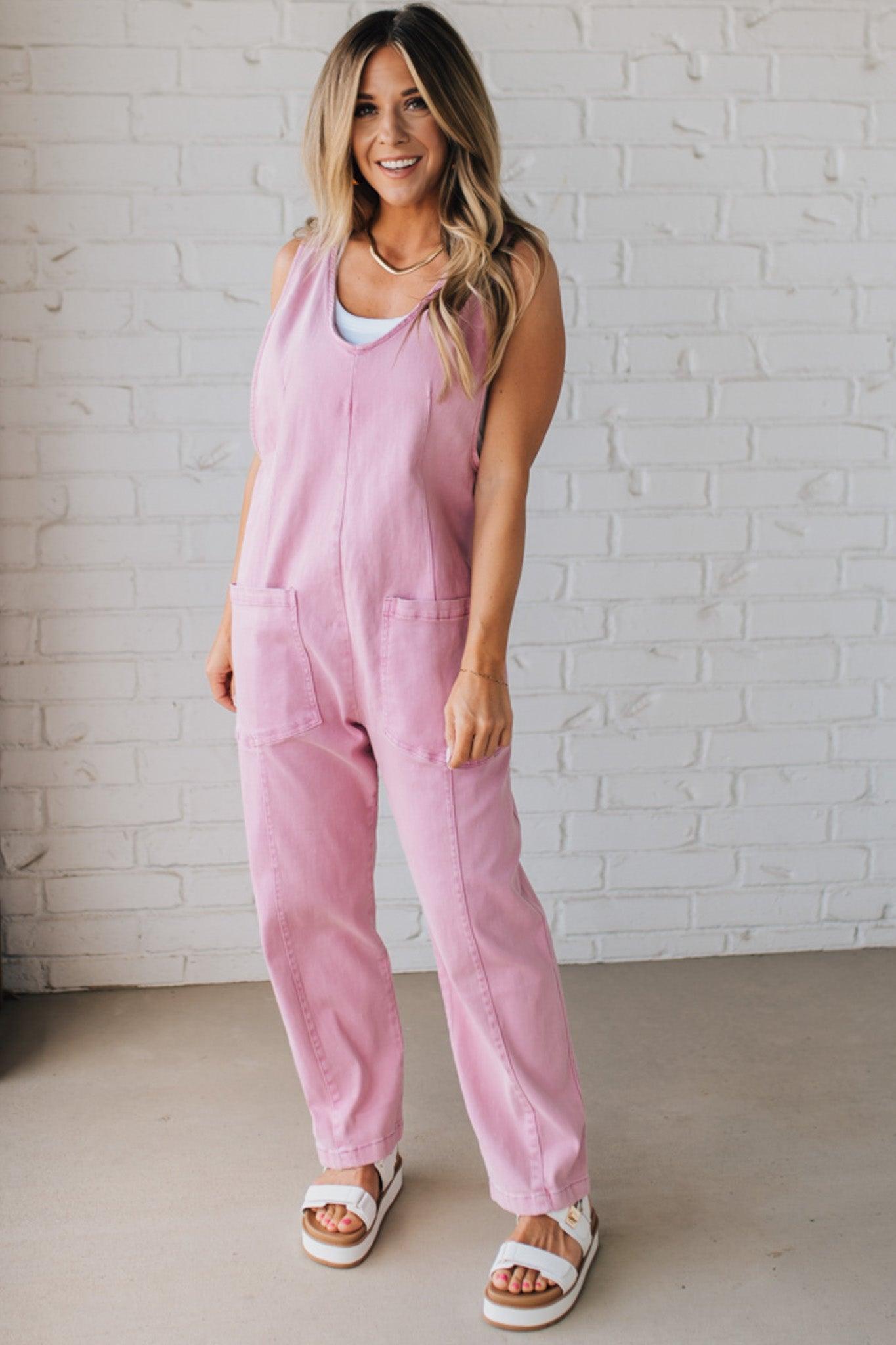 BLONDE WOMAN WEARING A CASUAL ADJUSTABLE STRAP BAGGY JUMPSUIT WITH POCKETS AND A DEEP V NECKLINE.