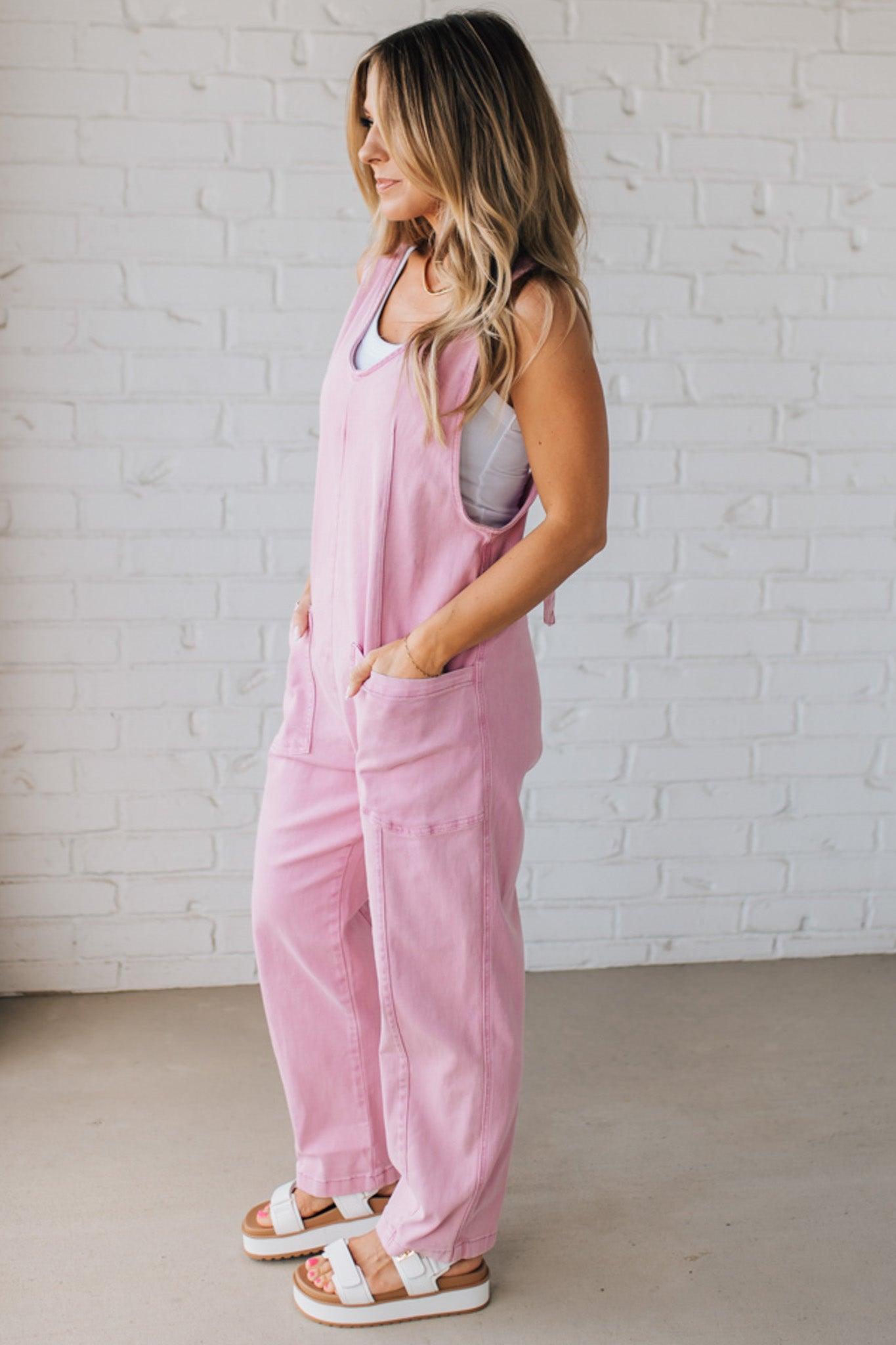 BLONDE WOMAN WEARING A CASUAL ADJUSTABLE STRAP BAGGY JUMPSUIT WITH POCKETS AND A DEEP V NECKLINE.