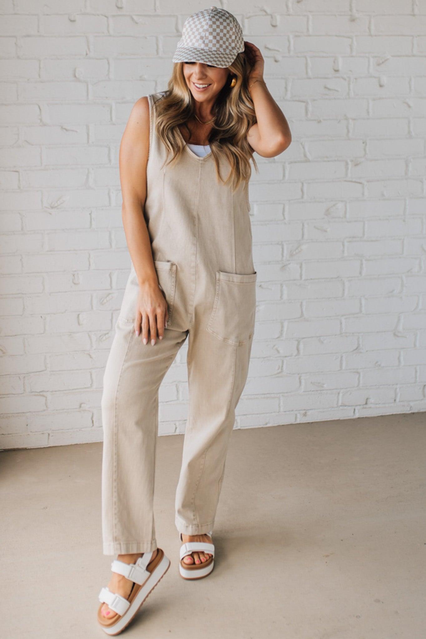 BLONDE WOMAN WEARING A CASUAL ADJUSTABLE STRAP BAGGY JUMPSUIT WITH POCKETS AND A DEEP V NECKLINE.
