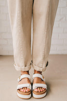 BLONDE WOMAN WEARING A CASUAL ADJUSTABLE STRAP BAGGY JUMPSUIT WITH POCKETS AND A DEEP V NECKLINE.