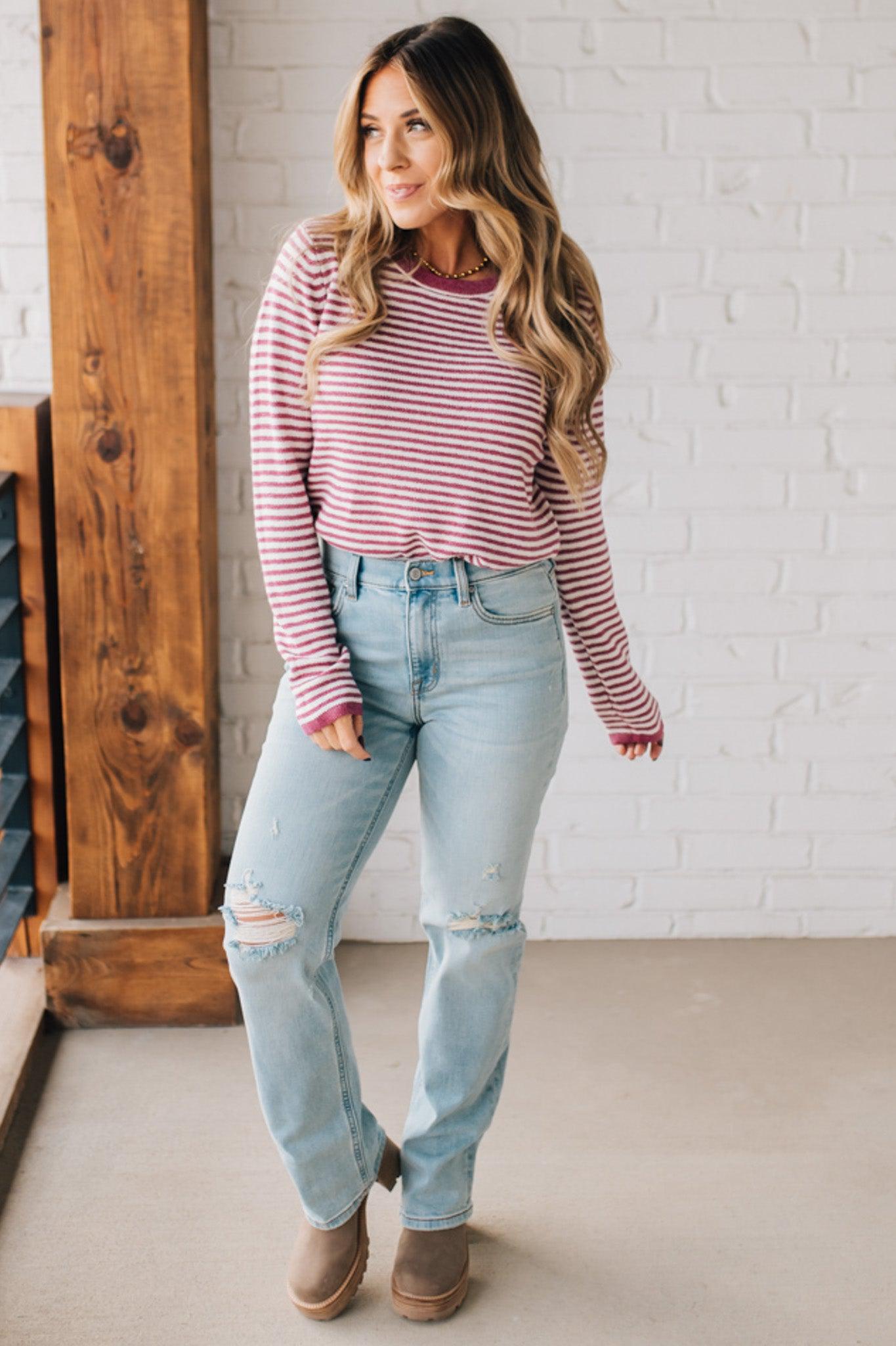 BLONDE WOMAN MODELING A LONG SLEEVE MAGENTA AND WHITE STRIPED SWEATER WITH SOLID MAGENTA ON THE NECKLINE AND SLEEVE CUFFS