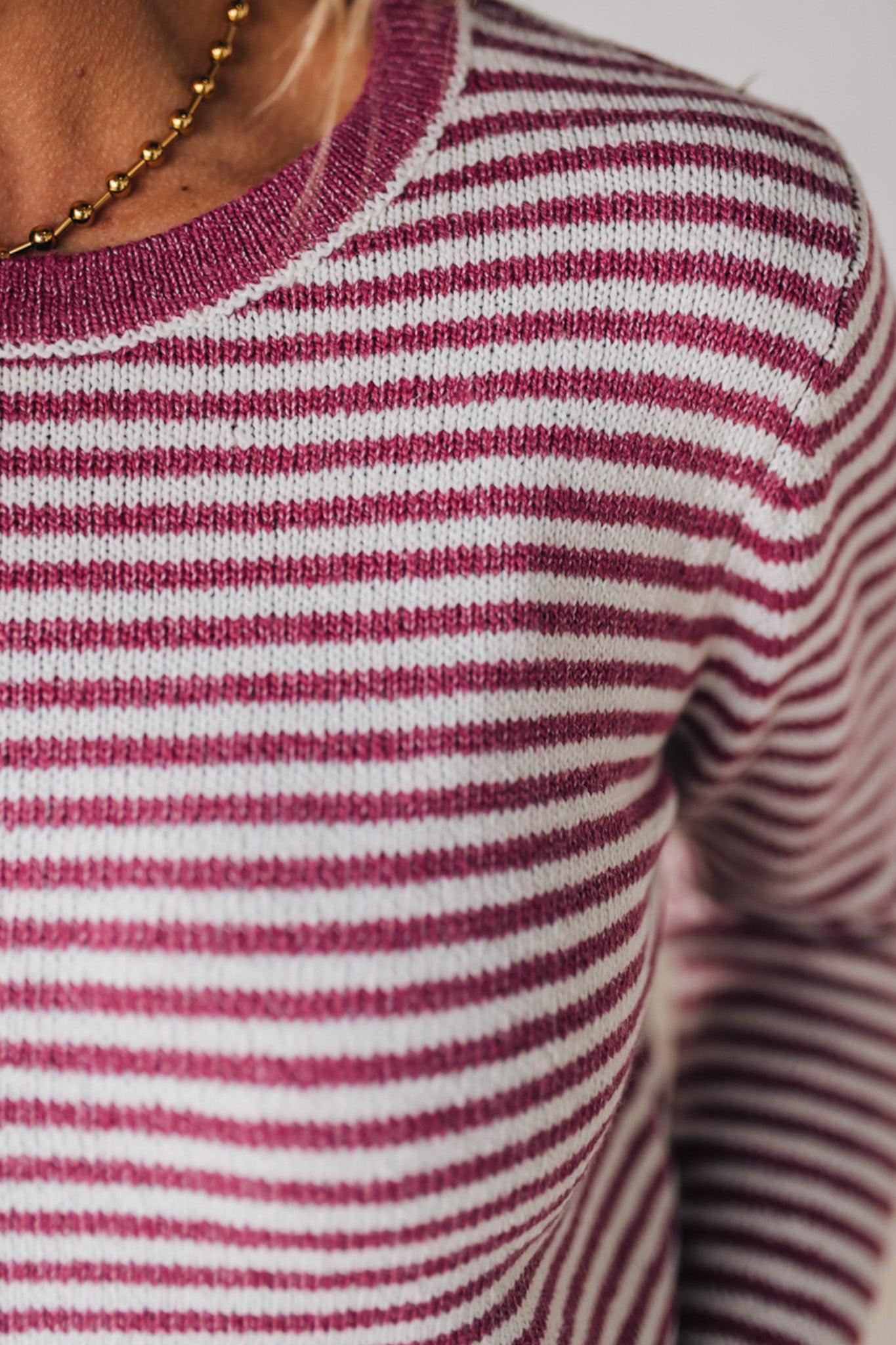 BLONDE WOMAN MODELING A LONG SLEEVE MAGENTA AND WHITE STRIPED SWEATER WITH SOLID MAGENTA ON THE NECKLINE AND SLEEVE CUFFS