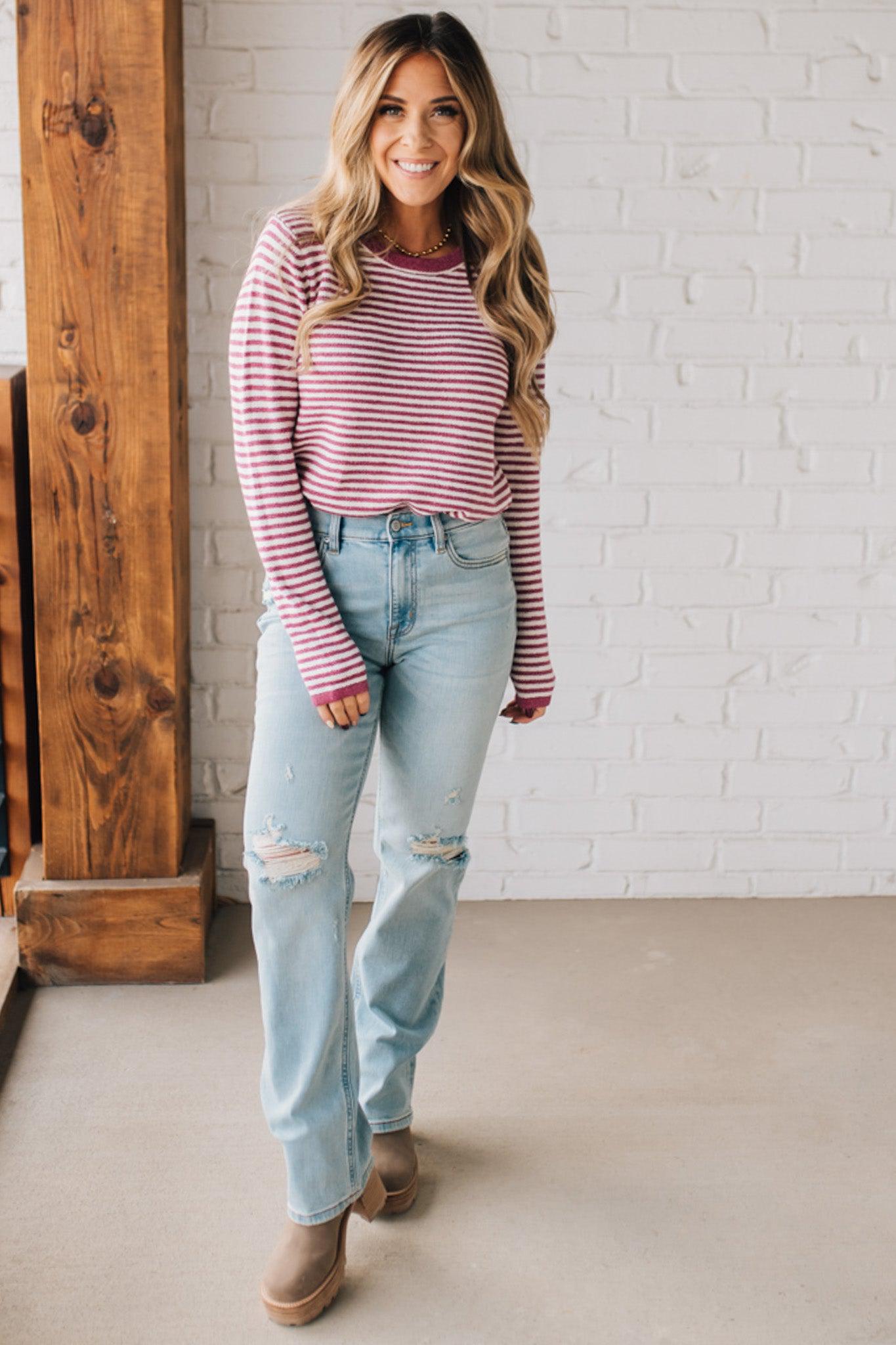 BLONDE WOMAN MODELING A LONG SLEEVE MAGENTA AND WHITE STRIPED SWEATER WITH SOLID MAGENTA ON THE NECKLINE AND SLEEVE CUFFS