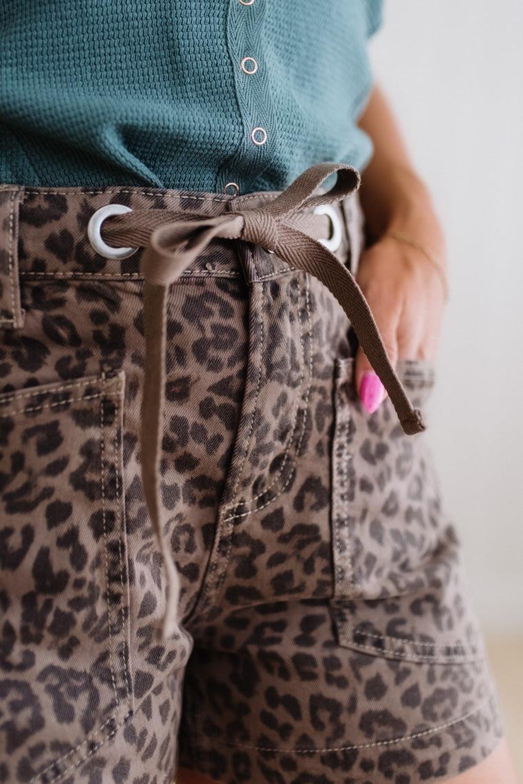 Leopard print shorts with a green shirt worn by a person.