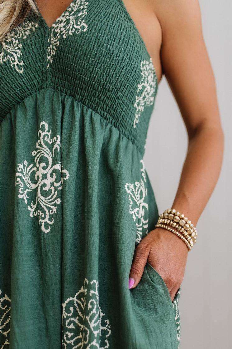 Green dress with white embroidery on a plain background