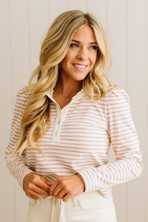 Woman wearing a striped shirt against a plain background