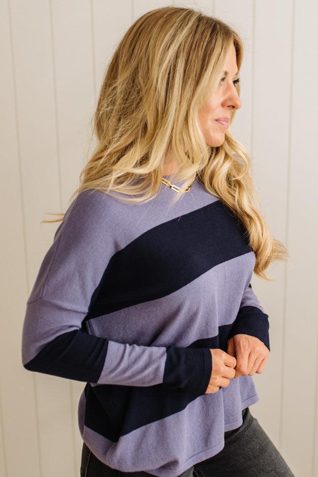 Woman wearing a striped sweater with a plain background