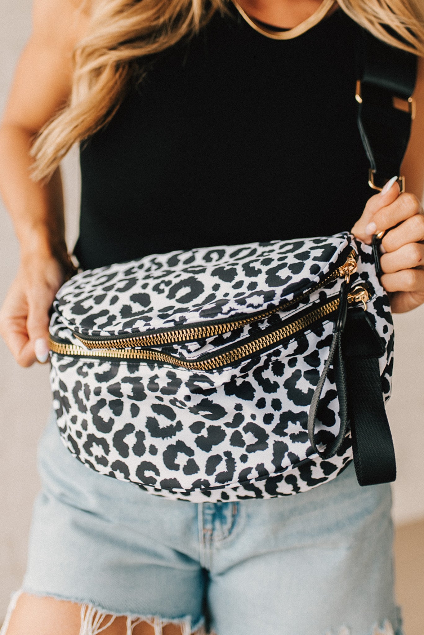 Black and White Oversize Leopard Double Zip Crescent Sling bag worn by a blonde woman.
