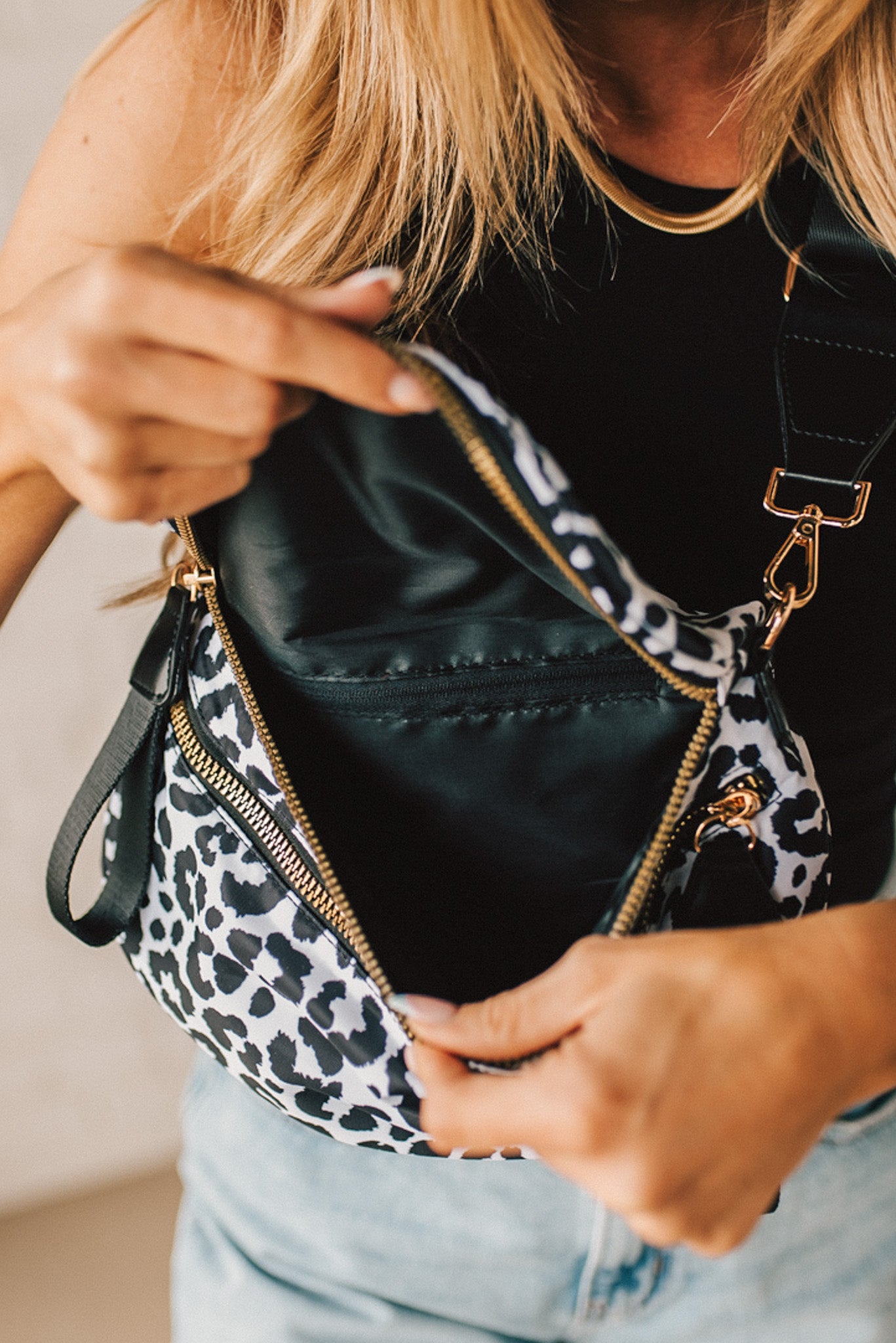 Black and White Oversize Leopard Double Zip Crescent Sling bag worn by a blonde woman.