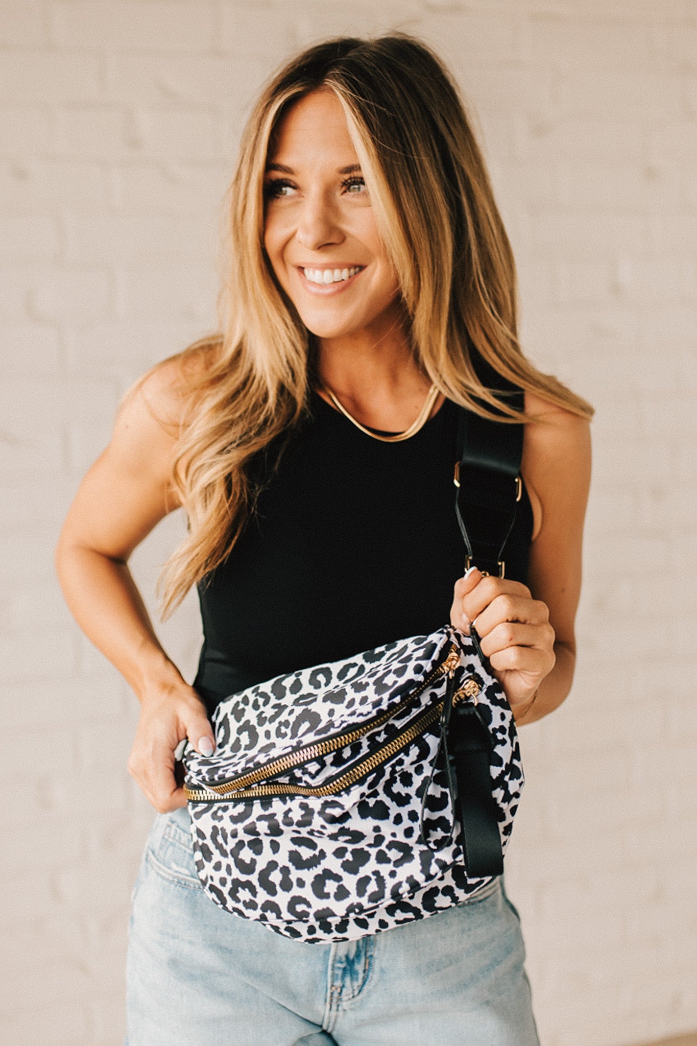 Black and White Oversize Leopard Double Zip Crescent Sling bag worn by a blonde woman.