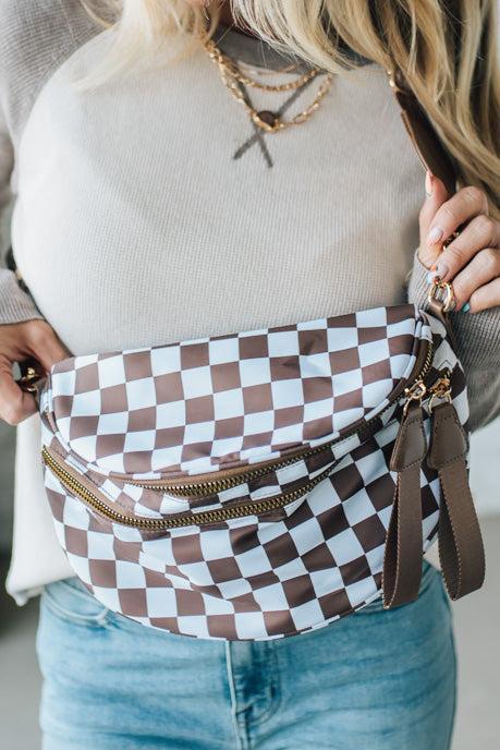 Person wearing a checkered fanny pack with a neutral background