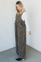 Blonde woman wearing wide leg overalls with all over leopard print and corduroy texture.