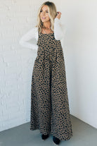Blonde woman wearing wide leg overalls with all over leopard print and corduroy texture.