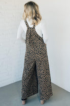 Blonde woman wearing wide leg overalls with all over leopard print and corduroy texture.