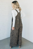 Blonde woman wearing wide leg overalls with all over leopard print and corduroy texture.
