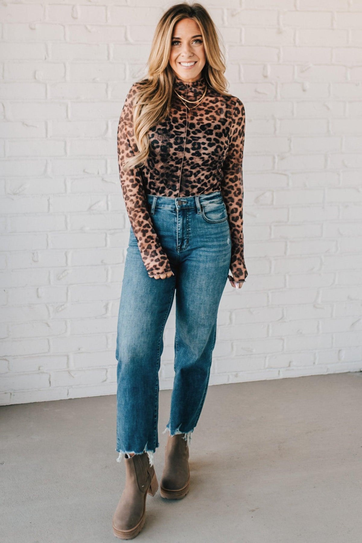 BLONDE WOMAN WEARING ANIMAL PRINTED LETTUCE EDGE MESH MOCK NECK TOP