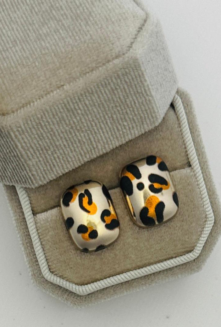 Leopard print earrings in a jewelry box on a light gray background