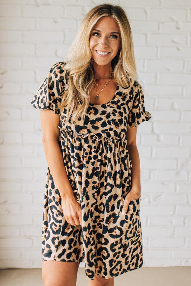 BLONDE WOMAN WEARING A LEOPARD PRINT WOVEN PUFF SLEEVES DRESS WITH PATCH POCKETS.