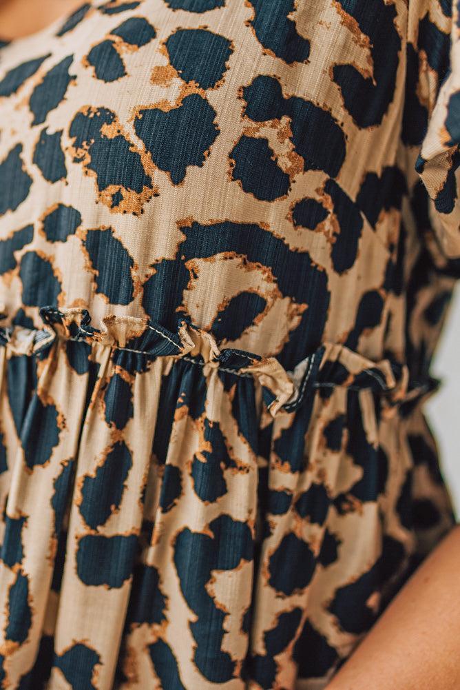 BLONDE WOMAN WEARING A LEOPARD PRINT WOVEN PUFF SLEEVES DRESS WITH PATCH POCKETS.
