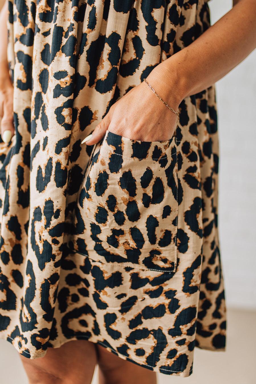 BLONDE WOMAN WEARING A LEOPARD PRINT WOVEN PUFF SLEEVES DRESS WITH PATCH POCKETS.