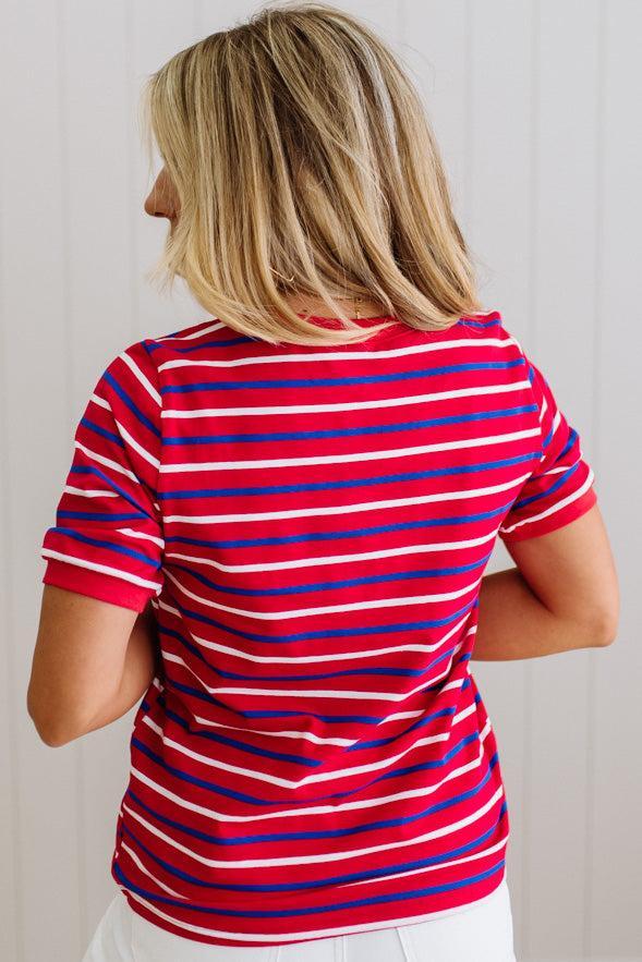 Person wearing a red and blue striped shirt against a white background
