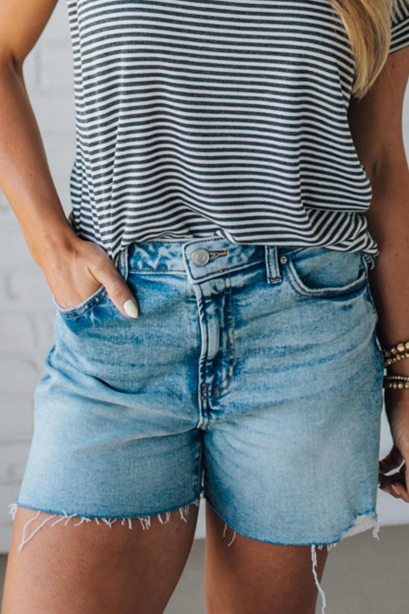 Woman wearing Acid Washed Raw Hem Shorts in Mid Rise.