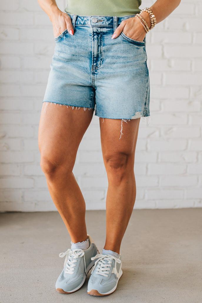 Woman wearing Acid Washed Raw Hem Shorts in Mid Rise.