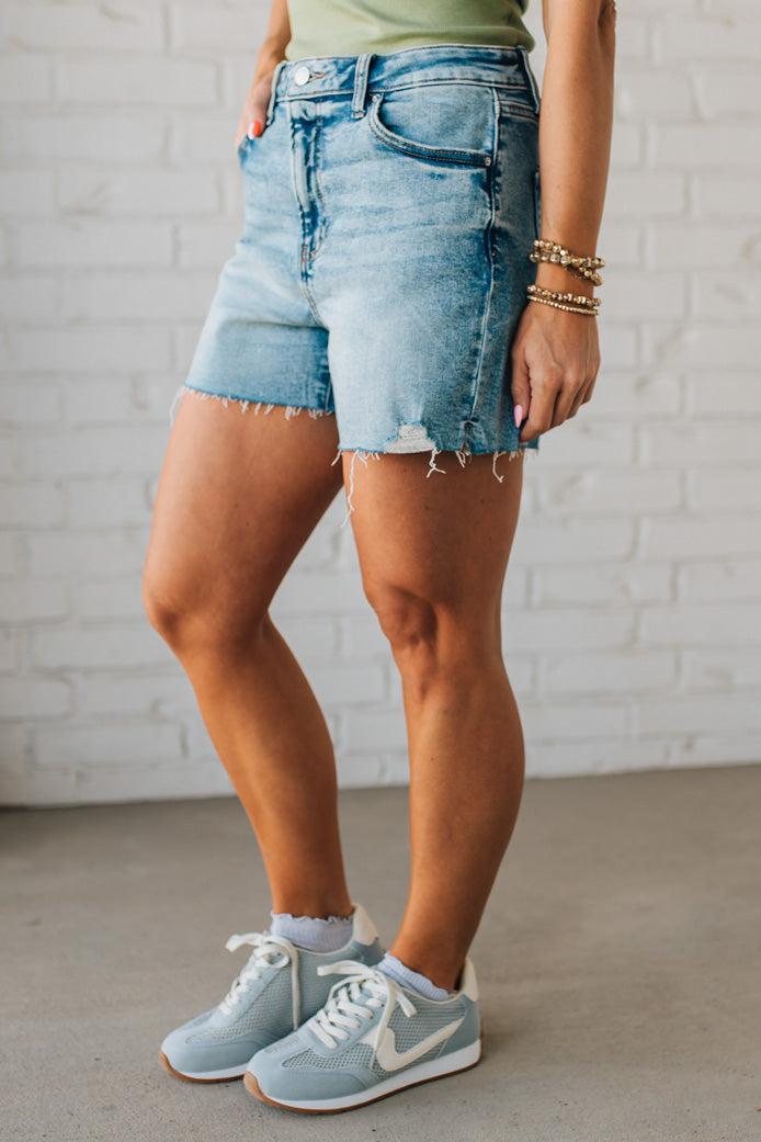 Woman wearing Acid Washed Raw Hem Shorts in Mid Rise.