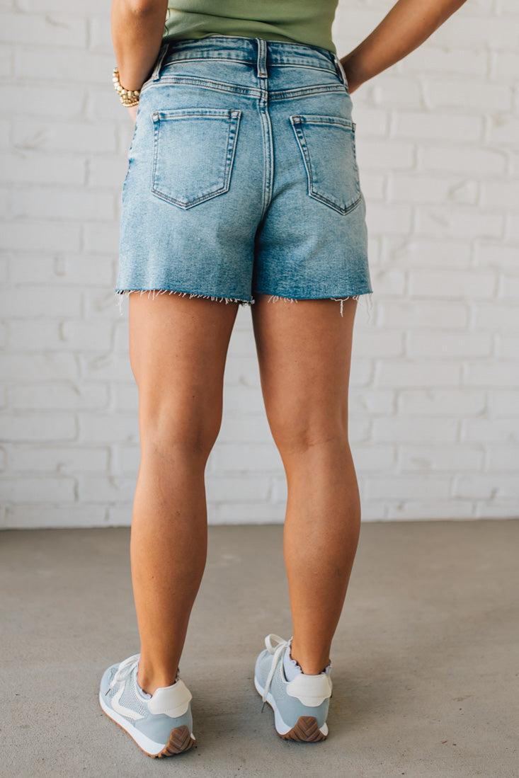 Woman wearing Acid Washed Raw Hem Shorts in Mid Rise.
