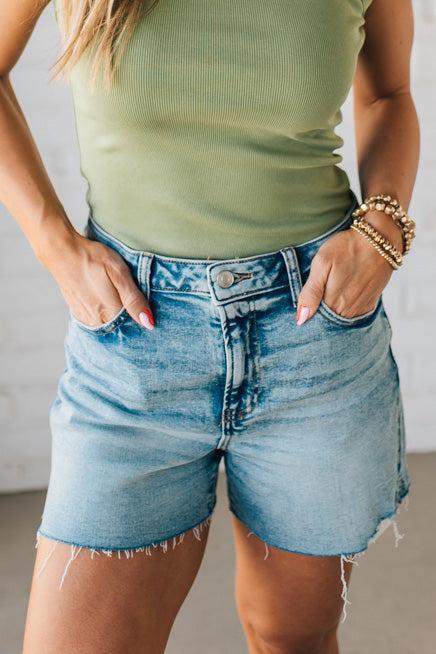 Woman wearing Acid Washed Raw Hem Shorts in Mid Rise.