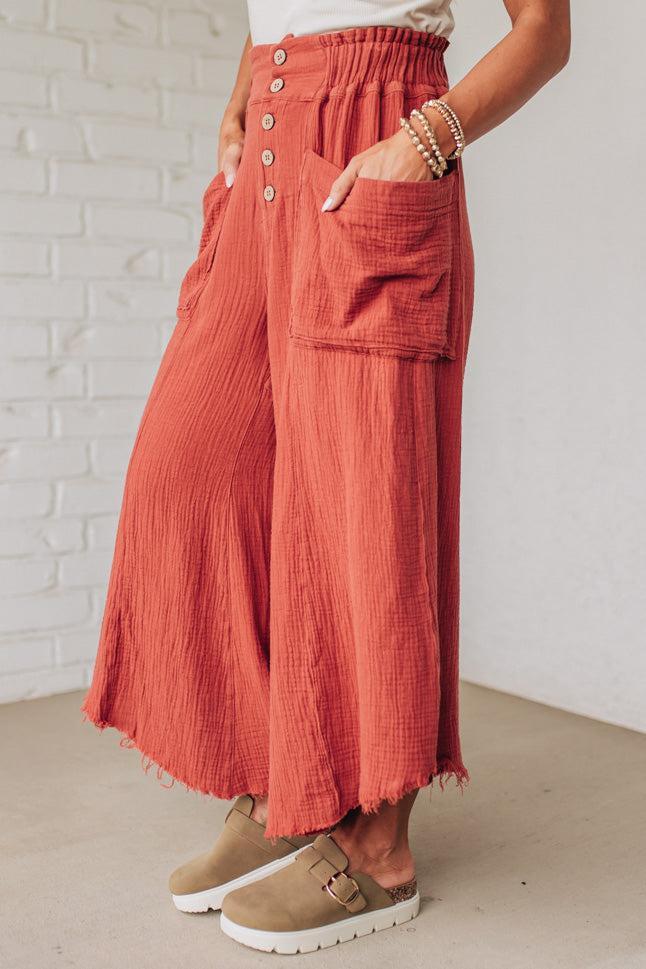 Person wearing red pants with a white brick wall background