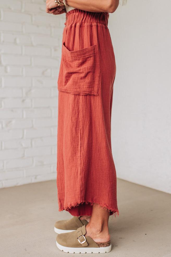 Person wearing a red skirt with a white brick wall background