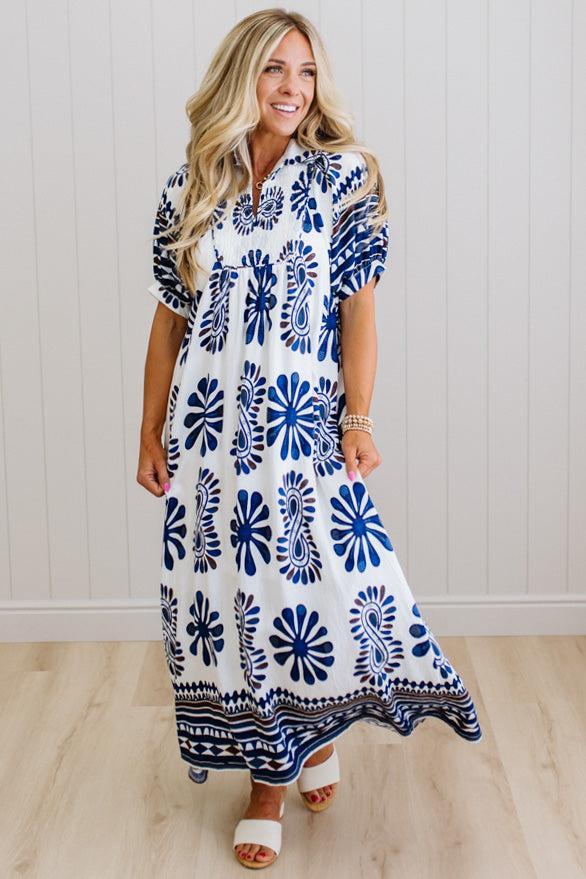 Woman wearing a blue and white patterned dress on a wooden floor.