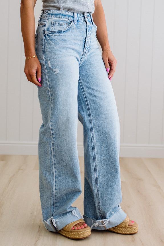 Person wearing light blue jeans with a white background
