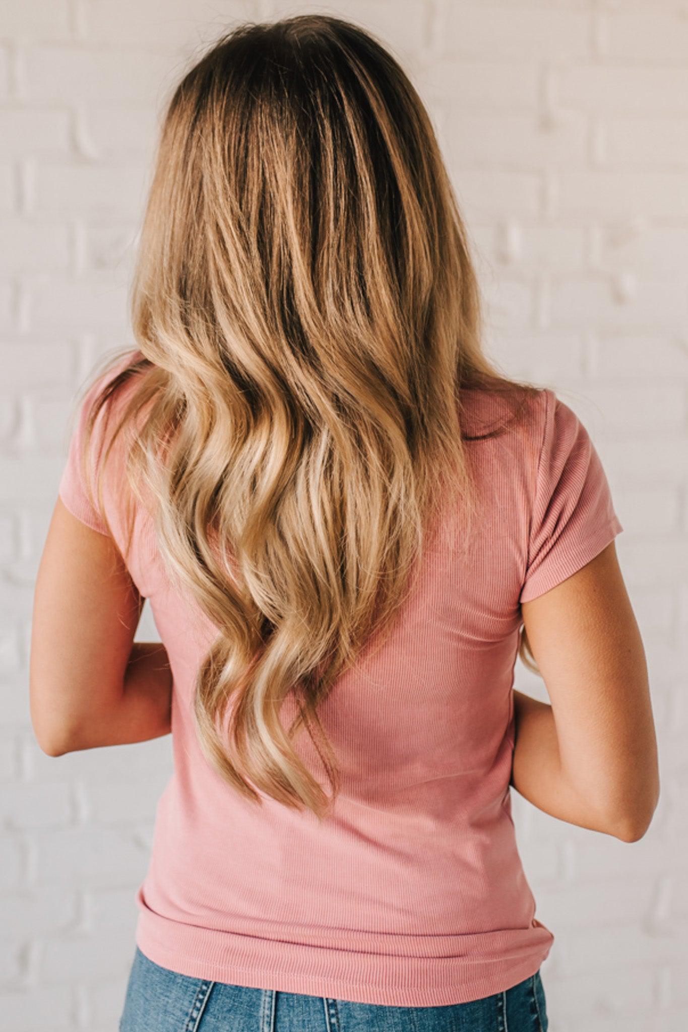 Blonde woman wearing a basic slim fit ribbed tee shirt.