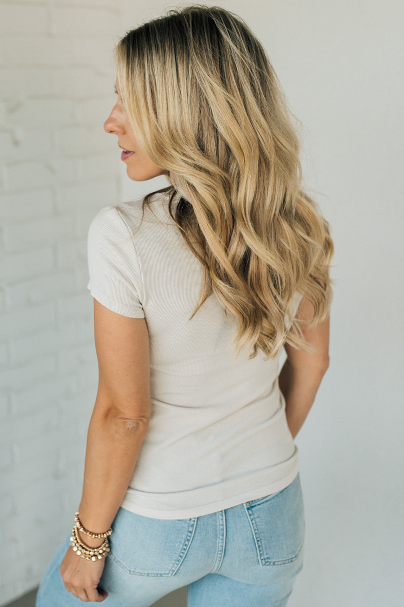 Blonde woman wearing a basic slim fit ribbed tee shirt.