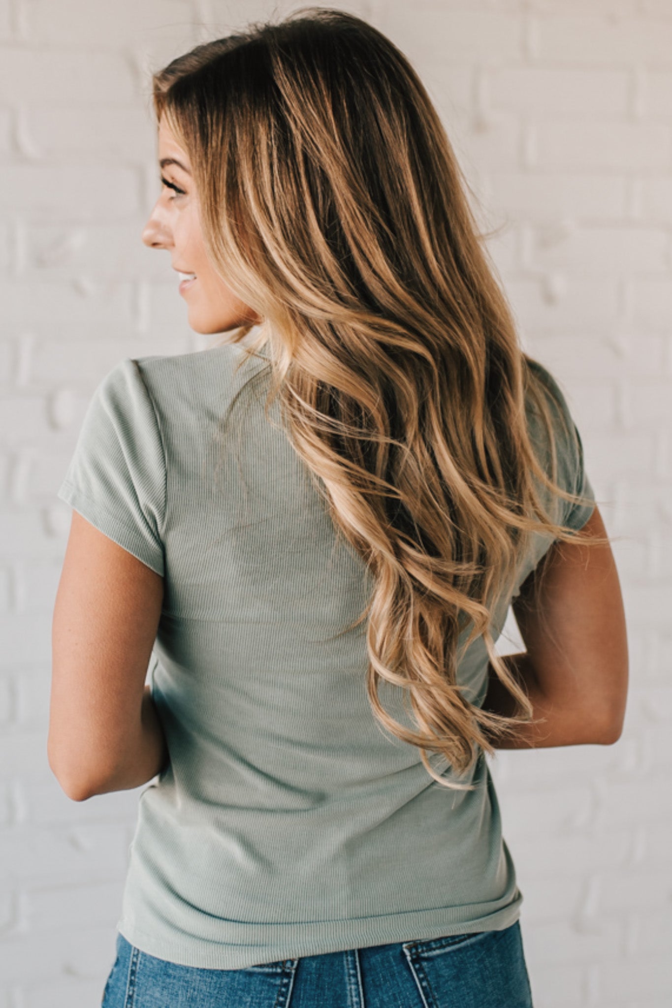 Blonde woman wearing a basic slim fit ribbed tee shirt.