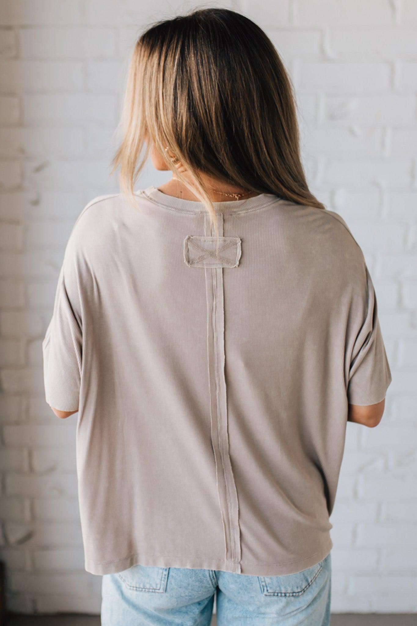 BLONDE WOMAN WEARING A SOLID MINERAL WASHED RIBBED CUFFED SHORT SLEEVE ROUND NECK TOP.