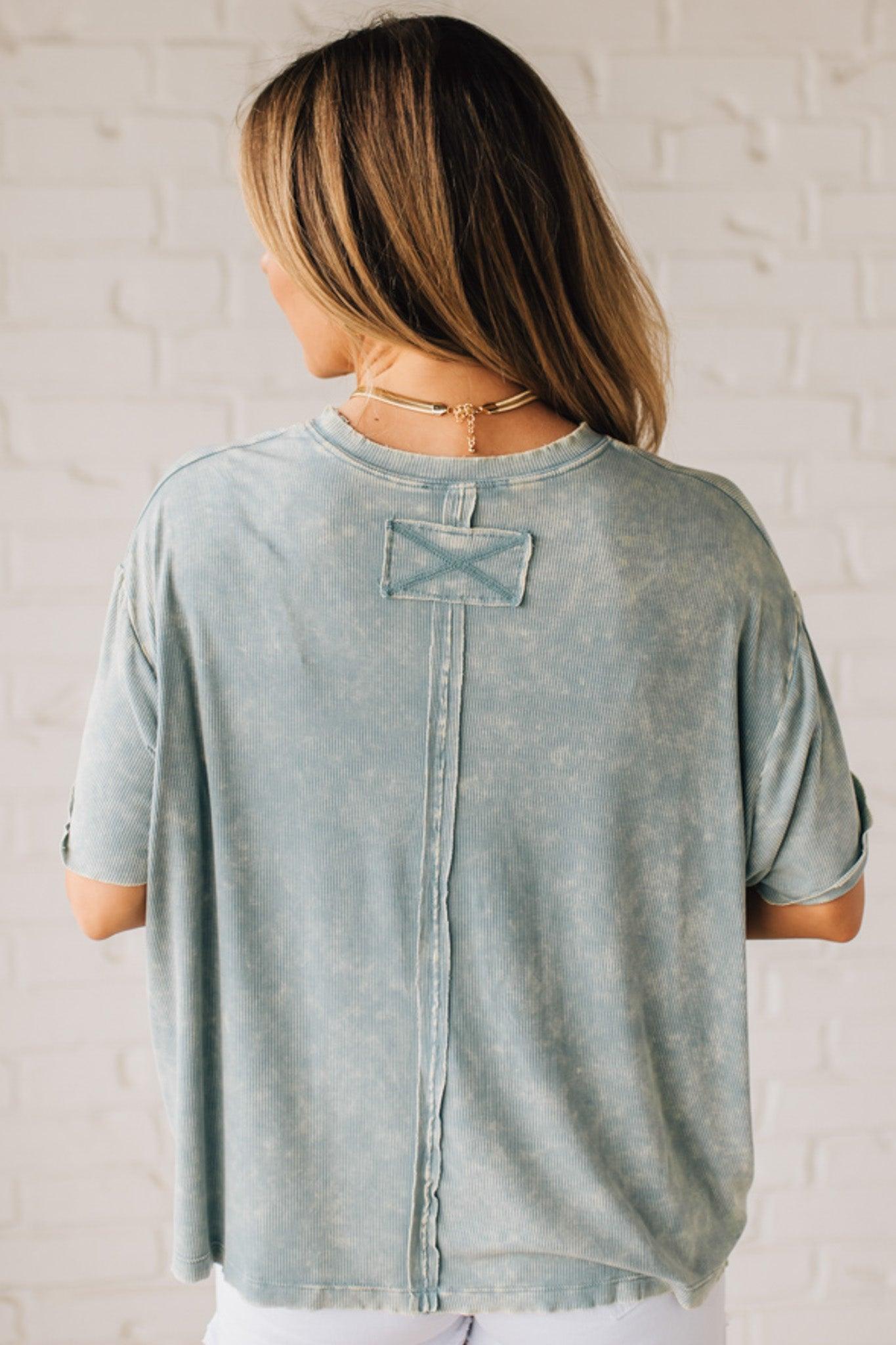 BLONDE WOMAN WEARING A SOLID MINERAL WASHED RIBBED CUFFED SHORT SLEEVE ROUND NECK TOP.