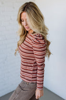 Woman wearing a red and white striped long-sleeve shirt against a plain background