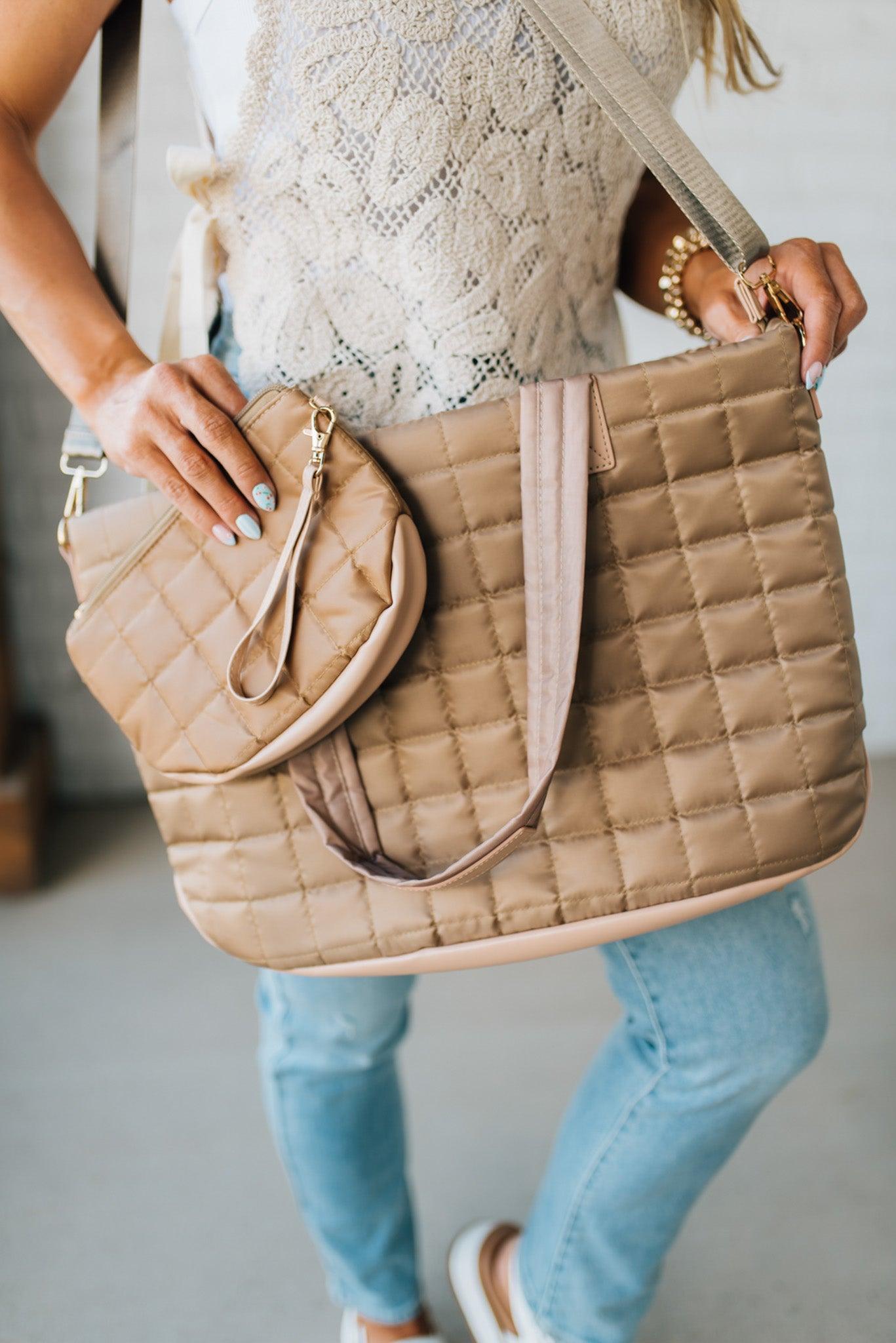 Woman holding a mocha nylon quilted traveler tote bag.