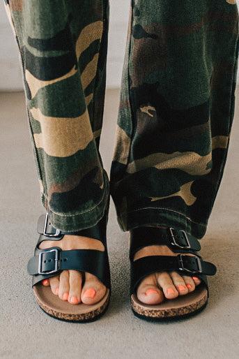 Ladies sandal slides with buckles and cork bottom in black faux leather.