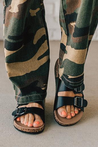 Ladies sandal slides with buckles and cork bottom in black faux leather.