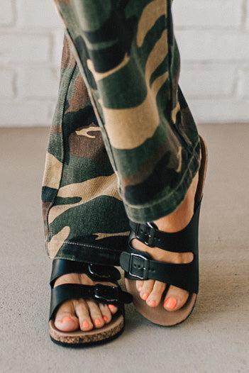 Ladies sandal slides with buckles and cork bottom in black faux leather.