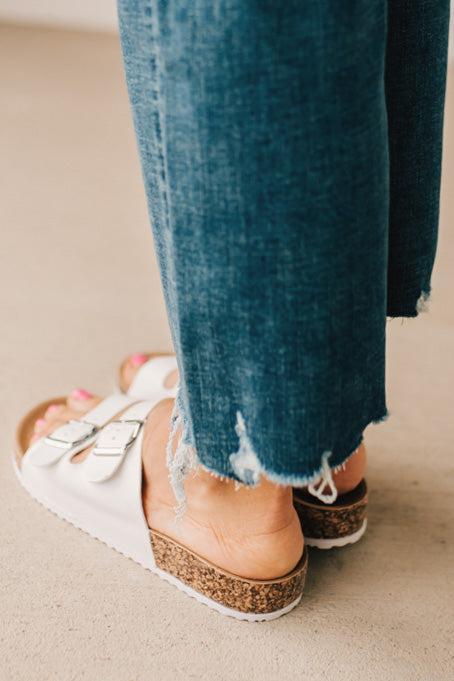 Ladies sandal slides with buckles and cork bottom in white faux leather.